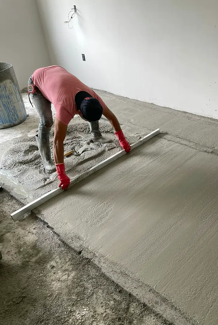Trabajador realizando nivelación de piso de concreto antes de instalar piso Boden